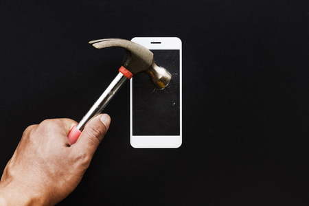 Male hand with hammer on tempered glass shield or film screen cover.Mobile phone protector concepts ideasの写真素材