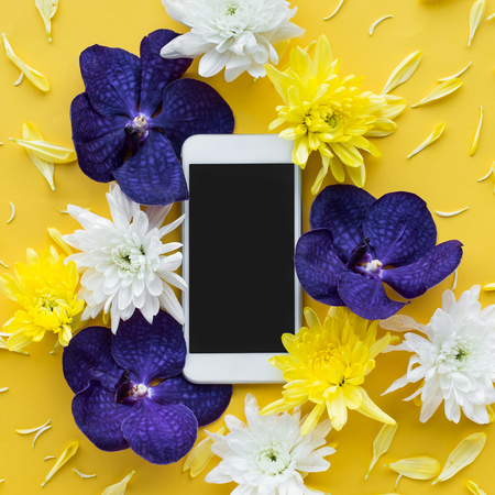 White smartphone with flower petal.flat lay design background.top viewの写真素材