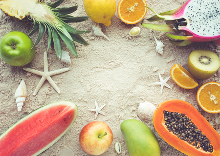 Group of fruits on sand background with shells.Top viewの写真素材
