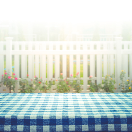 Checkered tablecloth on blur of white fence and garden background.For montage product display or design key visual layoutの写真素材