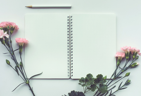 Home office desk table with notepad,flower on white background.Flat lay.feminine concepts design.minimalist styleの写真素材