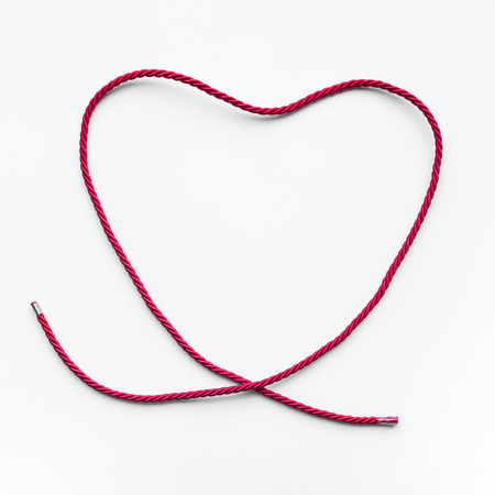 Heart shape from red yarn,rope on blue background.love,wedding,valentine concept ideasの写真素材