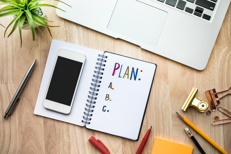 Business plan concepts with notepad paper on wooden table and supplies.flat lay designの写真素材