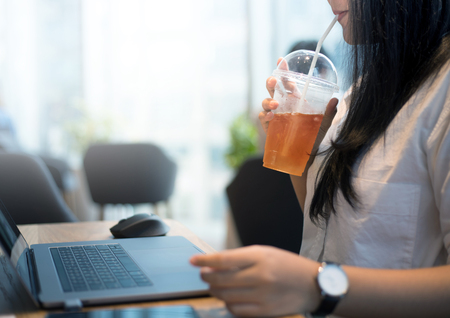 Young woman on work with drinking tea for refreshmentの写真素材
