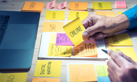 Online text on notepaper with male hand.Business brainstorming and communication marketing plan...