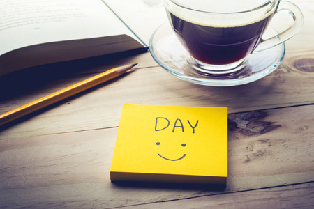 Day text with notepaper,notepad and coffee cup on desk table in morning.Motivation conceptsの写真素材