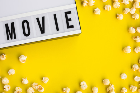 Movie text on light box with pop corn on pastel color background.Food and snack concepts ideas.Minimal styleの写真素材