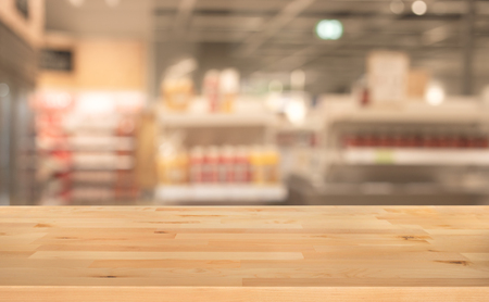 Wood table top on blur of supermarket product shelf background.business and shopping concepts ideasの写真素材