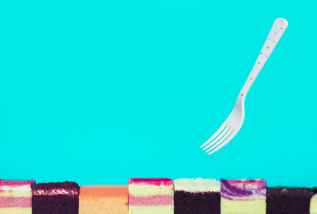 Colorful bakery slice with fork on blue background.Food and healthy concepts ideasの写真素材
