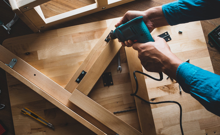 Carpenter man working with drill and furniture,fixing or repairing house.modern living concepts ideasの写真素材