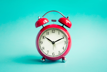 Close up red alarm clock on blue pastel background.timing concepts