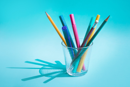 Colorful pen and pencil in glass with long shadow on pastel background.business creativity concept ideasの写真素材