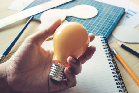 Businessman with lightbulb on desk in workplace.Ideas,creativity,inspiration and start up concept