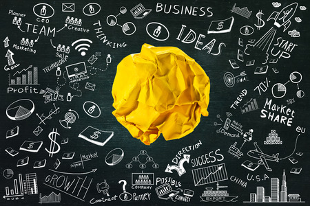 Yellow crumpled paper ball with business doodles set.ideas conceptの写真素材