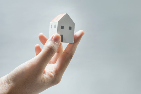 House model on human hands.Savings money,building construction,architecture,real estate and property conceptの写真素材