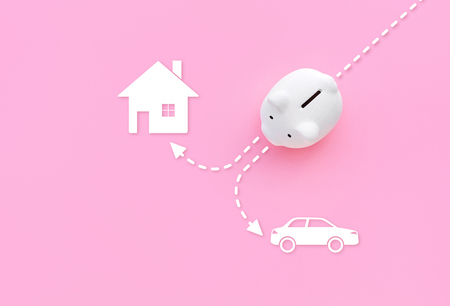 Piggy bank with home and car icon on pink pastel color background.money savings and financial concepts ideasの写真素材