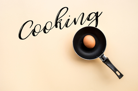 Egg fried on black pan with cooking text on desk table  background.Food concepts ideasの写真素材