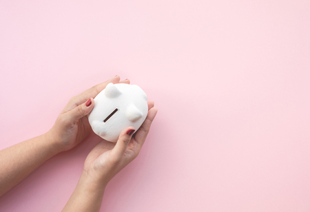 Female holding  piggy bank on pastel color background.savings and financial concepts ideas.copy spaceの写真素材