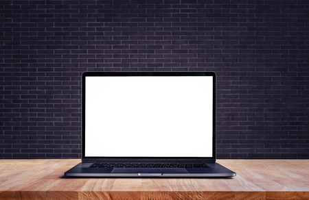 Modern computer,laptop with blank screen on table and brick wall backgrounds,For presentation and communication ideasの写真素材
