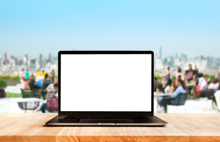 Modern computer,laptop with blank screen on desk table cafe with community park backgrounds,For presentation and communication ideasの写真素材