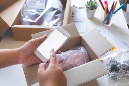 Online shopping concepts with young female buying product on smartphone and some her product on table.Ecommerce,shipping delivery service.Business retail marketの写真素材