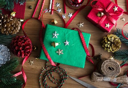 Merry christmas concepts with decorate gift box present and ornament element on wood table background.winter season's greetingactivity ideas.top viewの写真素材