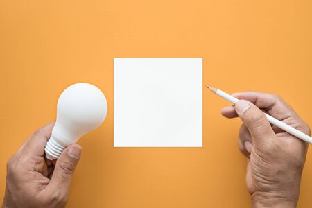 Creativity inspiration,ideas concepts with lightbulb and notepad on pastel color background.Flat lay design.の写真素材