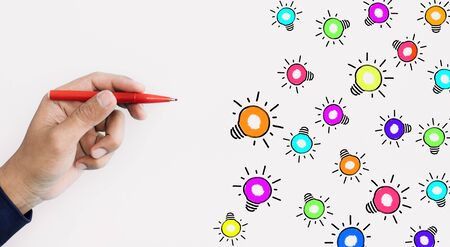 Ideas inspiration concepts with hand using pen drawing colorful lightbulb on white background.Business creativity.human performanceの写真素材