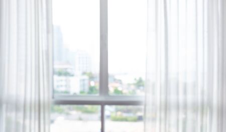 Blur of white curtain on window with city view background in morningの写真素材