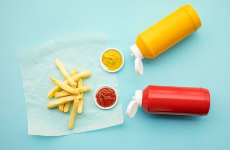 Top view of french fried with tomato sauce ( ketchup ) and mustard on color table background.Fast food and unhealthy eating concepts ideasの写真素材