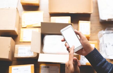 Online shopping concepts with youngman using smartphone on a lot of packag box.Ecommerce marke.Transportation logistic.Business retail marketの写真素材