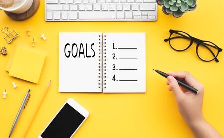 Goal concepts young female writing checklist with notepad on color desk table.business plan ideasの写真素材