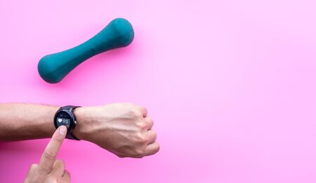 Young man using smartwatch device and fitness program with dumbbell.Sport technology.Modern life and body healthy concepts ideasの写真素材