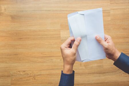Male holding paper envelope, letter on floor wood. business concepts ideas