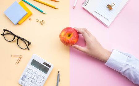 Fruit and healthy concepts with young female holding red apple on desk worktable background.organic and nature ideasの写真素材