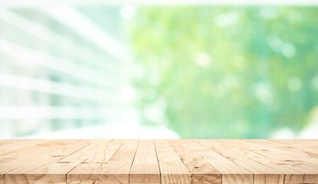 Empty wood table top on blur abstract green garden from window view background.For montage product...