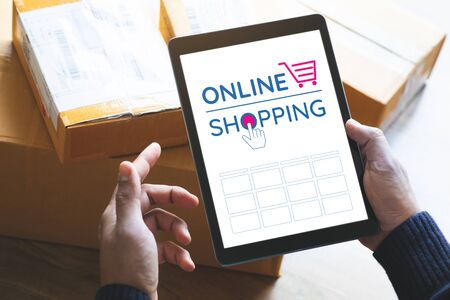 Online shopping concepts with youngman using tablet on product package box.Ecommerce market.Transportation logistic.Business retail.Seller and buyerの写真素材