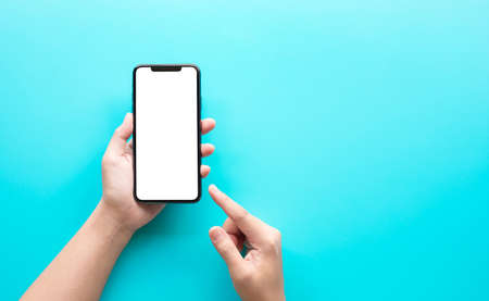 Female hand using smartphone with blank screen on color background.technology and connectivity...