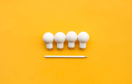 Business creativity and inspiration concepts with lightbulb and pencil on yellow background....