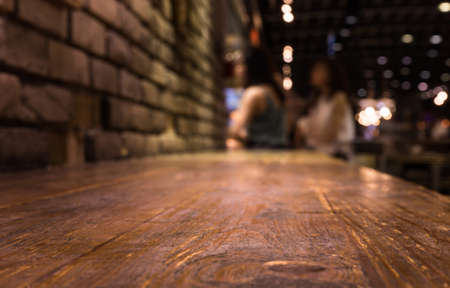 Wood bar (table) on cafe in dark night with people and light background/selective focus.For montage...