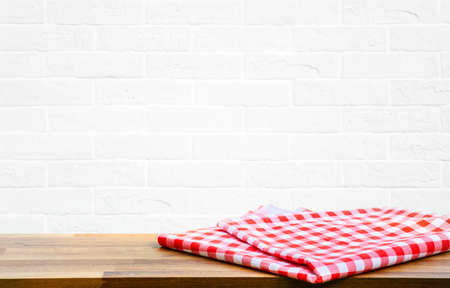 Checked tablecloth on wood with blur white brick wall kitchen background.for key visual food and drink products.の写真素材