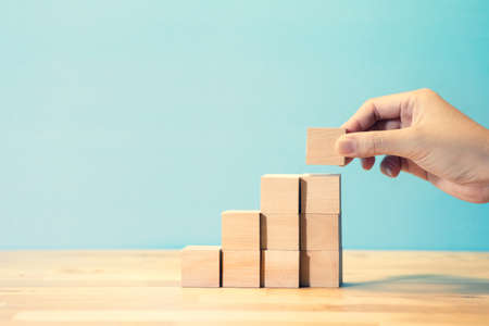 Business growth or step for success concepts with person hand putting wood blog step.copy space