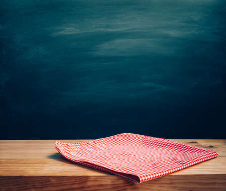 Red checked tablecloth on wood with blur dark background.Design for key visual food and drink...