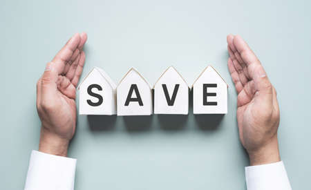 Business property,real estate and financial concepts with save text and investor hand and white model house.の写真素材