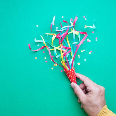 Celebration,party backgrounds concepts ideas with hand holding colorful confetti,streamers.Flat lay designの写真素材