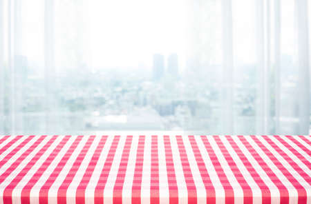 Red tablecloth on wood with blur home window background.For food and drink ads designの写真素材