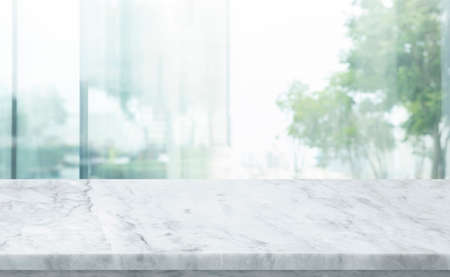 Selective focus.Marble table top on blur abstract cwindow glass background.For montage product...