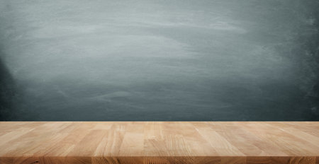 Selective focus of wood table top on blur dark blackboard background.For create product display or design key visual layout.の写真素材