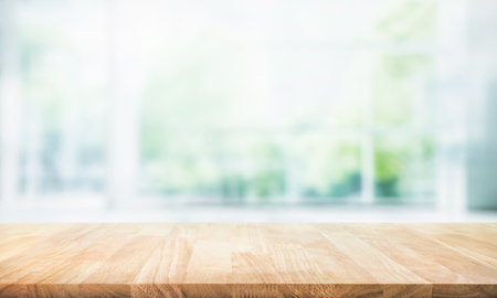 Selective focus.Empty of wood table top on blur of curtain with window and green from garden background.For montage product display or design key visualの写真素材