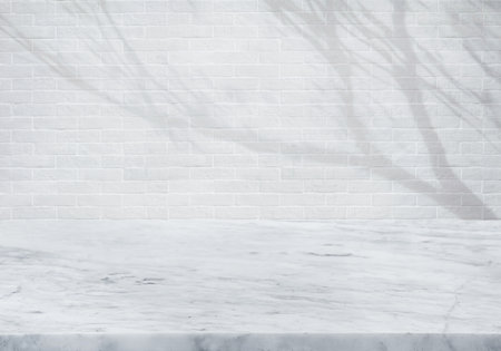 Selective focus.marble countertop or product display platform design with shadow tree on brick wall background.luxury minimal presentationの写真素材